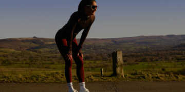 Uma mulher cansada depois de poucos minutos de corrida, pois ainda não sabe como respirar na corrida de forma correta